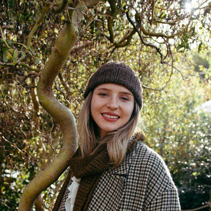Model wearing the alpaca wool chunky hat and scarf knitting kit uses alpaca yarn from British and Irish farms. Shown here in Speckledy Grey.