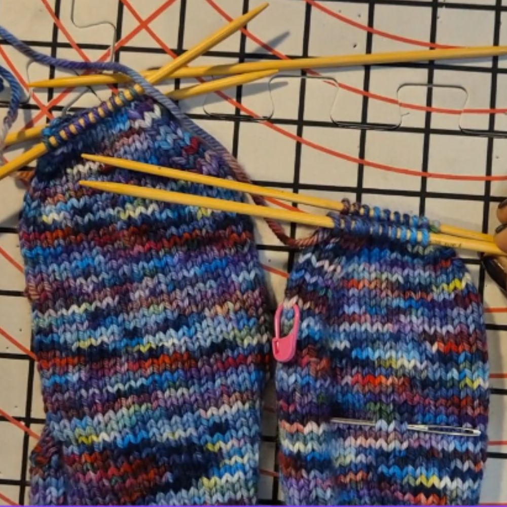 Load video: Instructions on how to do kitchener stitch using a third knitting needle.