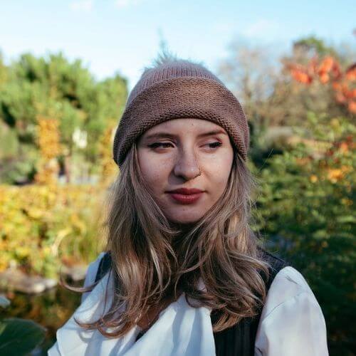 Kiki wearing the beginner hat rolled up knitted in DK alpaca wool from British and Irish farms