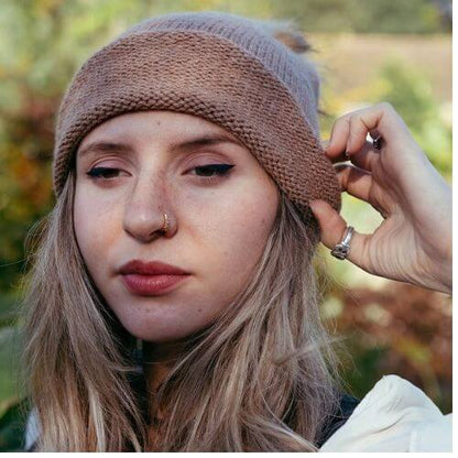 Kiki wearing the beginner hat rolled up knitted in DK alpaca wool from British and Irish farms