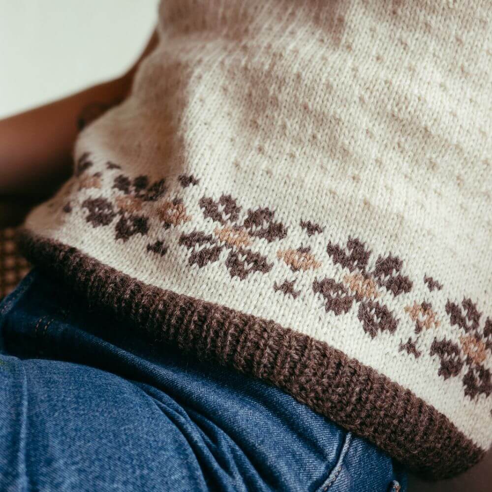 Close-up of a person wearing the Southwold Fair Isle sleeveless vest, showing the Fair Isle pattern.